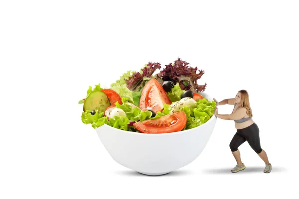 Femme en surpoids poussant un bol de salade — Photo