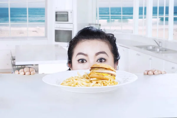 Cabeza de mujer con hamburguesa de queso en casa — Foto de Stock
