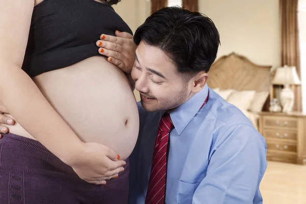 Šťastný manžel usmívající se těhotné bříško — Stock fotografie