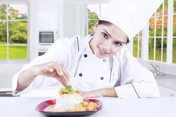 Vrouwelijke chef-kok peterselie zetten de schotel — Stockfoto