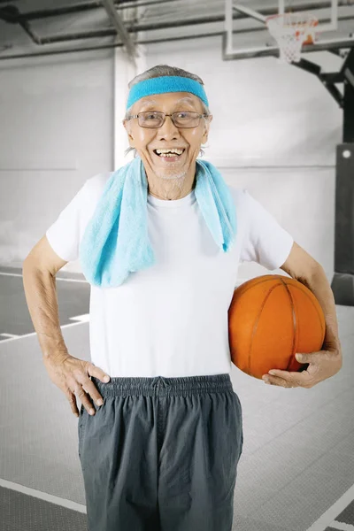 Elderly man carrying a basketball