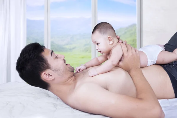 Cute boy lying on chest of father — Stock Photo, Image
