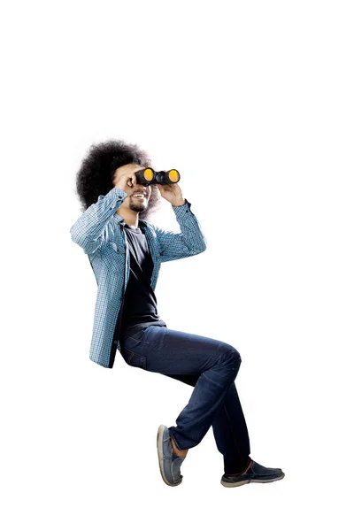 Afro student pomocí binokulární na studio — Stock fotografie