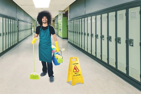 Afro criada de pie con un cartel de suelo mojado — Foto de Stock