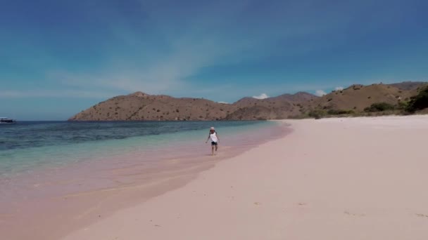 Ребенок бегает по розовому пляжу на острове Комодо — стоковое видео