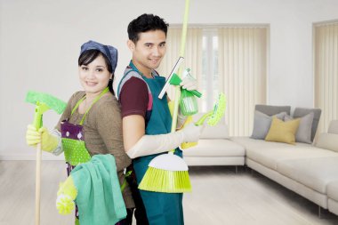 Genç çift temizleme ekipmanı tutar