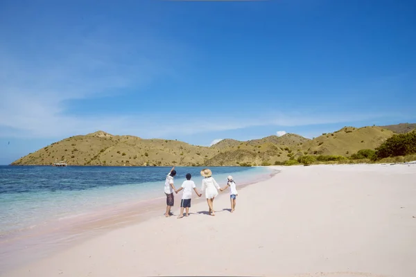 Junge Familie blickt auf eine Landschaft am Strand — Stockfoto