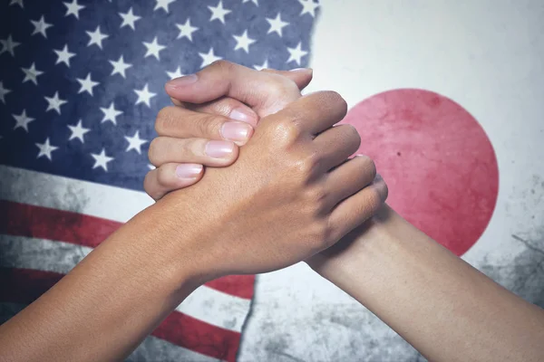 Två händer med Japan och USA flagga — Stockfoto