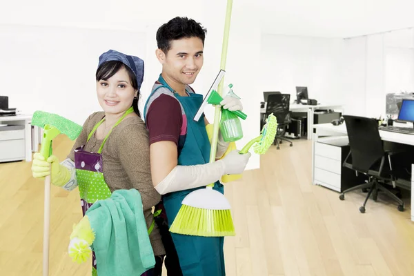 Janitors detém equipamentos de limpeza no escritório — Fotografia de Stock