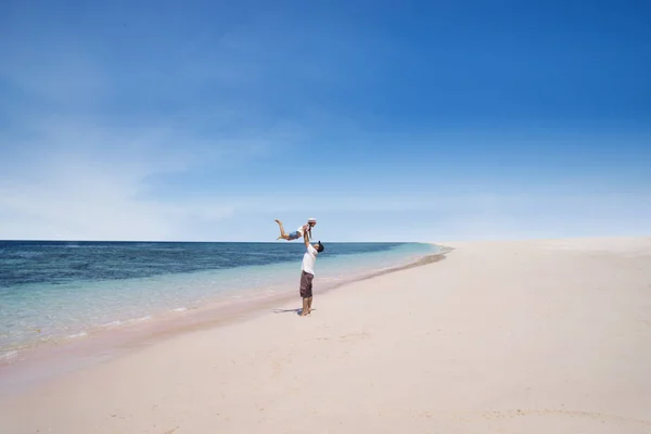 Vader liften dochter in het strand — Stockfoto