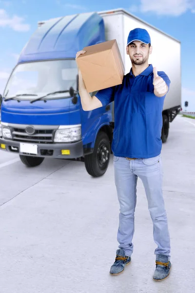 Człowiek dostawy z kciuk w górę i ciężarówki — Zdjęcie stockowe