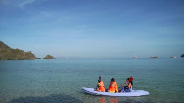 Mujer y niños piragüismo en la playa — Vídeo de stock