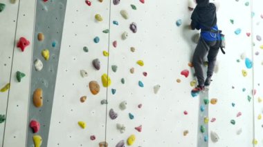 Müslüman kadın kapalı bir kaya duvarı tırmanıyor