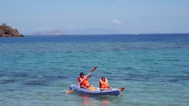 Glada barn kajakpaddling på stranden — Stockvideo