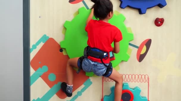 Niño escalando una pared divertida en el interior — Vídeos de Stock