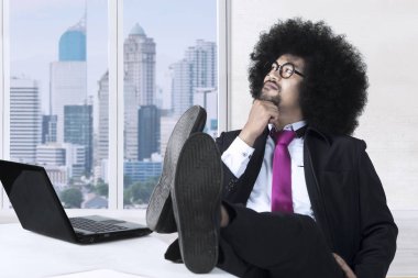 Pensive Afro businessman near the window