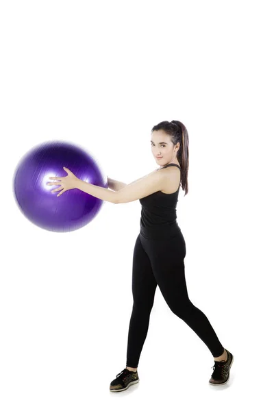 Красивая женщина с фитнес-мячом на студии — стоковое фото