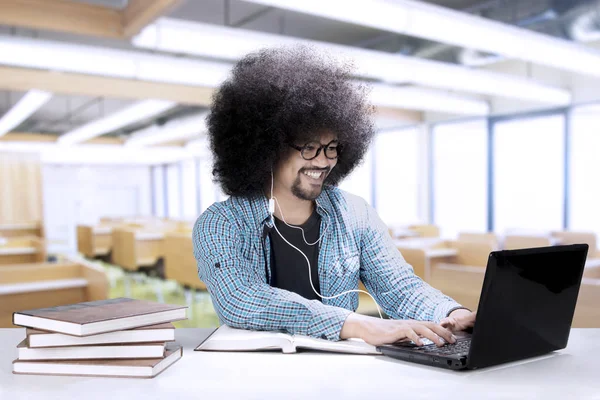 Mannelijke student met een laptop en de oortelefoon — Stockfoto