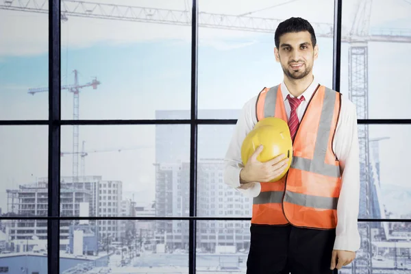 Italian foreman holds his helmet in the office