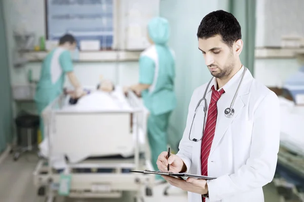 Médico italiano escribiendo en el portapapeles — Foto de Stock