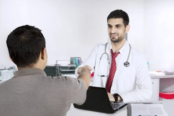 Italienischer Arzt beim Händedruck mit dem Patienten in der Klinik — Stockfoto