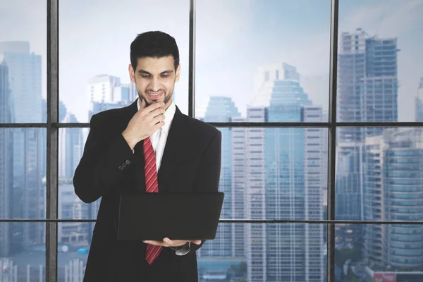 Homem de negócios árabe com laptop no escritório — Fotografia de Stock