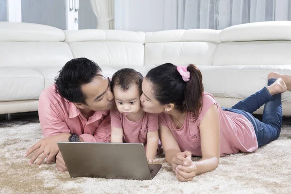 Entzückendes Baby von ihren Eltern geküsst — Stockfoto