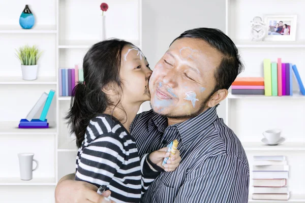 Cute girl kisses her father at home — Stock Photo, Image