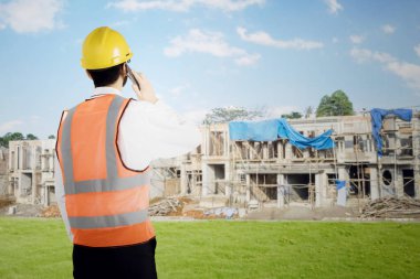 Genç foreman smartphone üzerinde konuşuyor