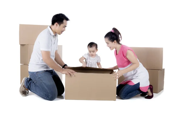 Jovem família desempacotando papelão no estúdio — Fotografia de Stock