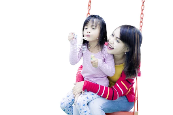 Frau mit Kind spielt auf der Schaukel — Stockfoto