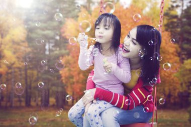 Anne ve kızı sabun köpüğü üfleme