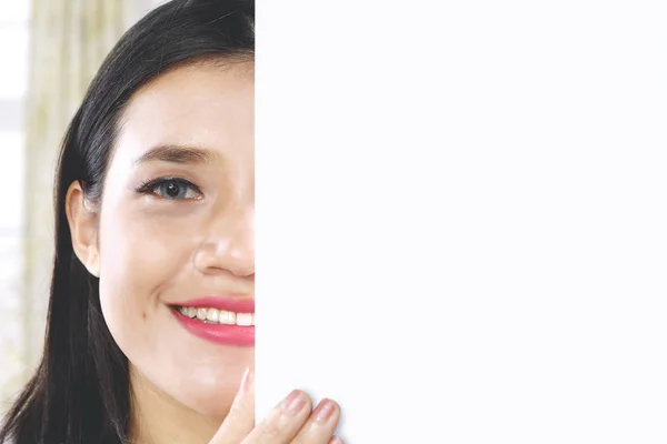 Shy girl peeping behind an empty whiteboard — Stock Photo, Image