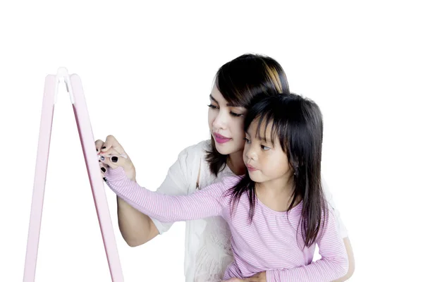 Mulher bonita ajudando sua filha a escrever — Fotografia de Stock