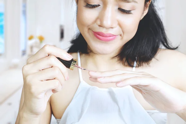 Pretty woman applying nail polish — Stock Photo, Image