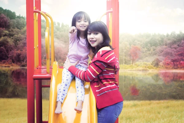 Mère et fille souriant sur la glissière — Photo