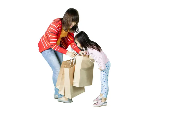 Mãe e criança olhando em sacos de compras — Fotografia de Stock