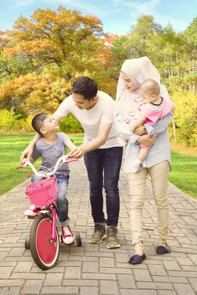 Menino e sua família com bicicleta — Fotografia de Stock