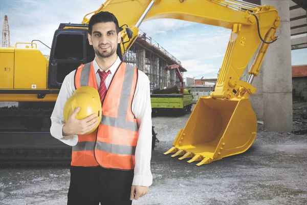 Amical architecte arabe debout près d'un tracteur — Photo