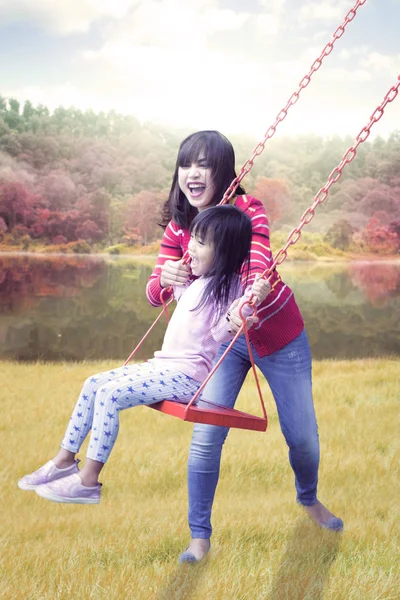 Familia jugando swing en el parque de otoño — Foto de Stock