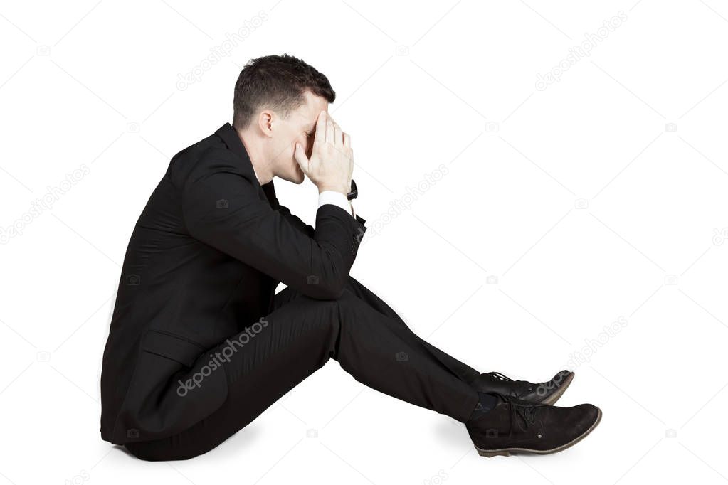 Frustrated businessman sitting in studio