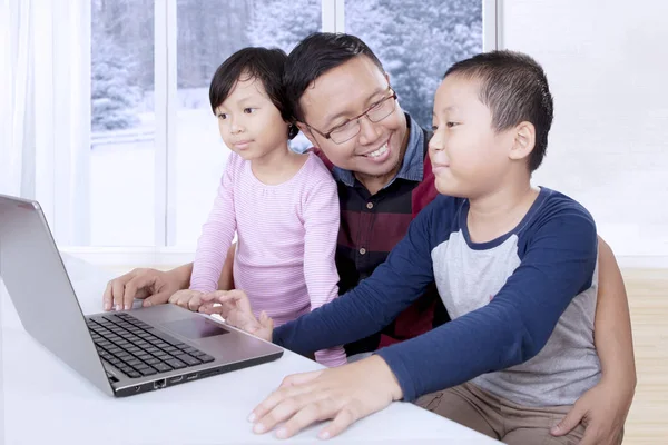 Junger Vater mit seinen Kindern am Laptop — Stockfoto