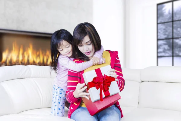 Família abre um presente de Natal no sofá — Fotografia de Stock