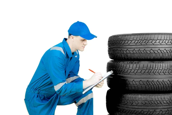 Técnico americano examinando pneus em estúdio — Fotografia de Stock