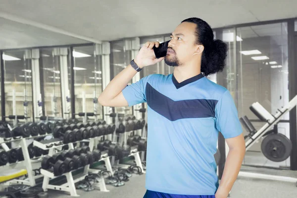 Afro homme avec smartphone dans le centre de fitness — Photo