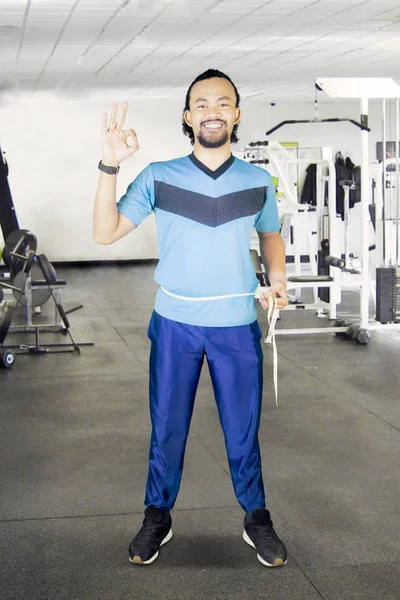 Afrikaanse man meten taille in het fitnesscenter — Stockfoto