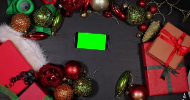  Smartphone ekran Xmas süslemeleri arasında el dokunuyor