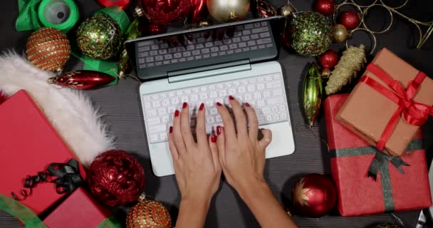 Руки с помощью ноутбука между рождественскими украшениями — стоковое видео