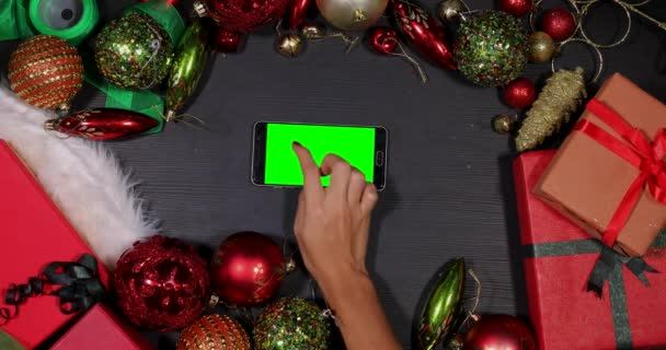 Mano utiliza teléfono inteligente entre la decoración de Navidad — Vídeo de stock