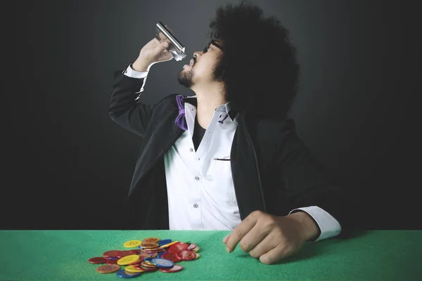 Young gambler drinking whiskey — Stock Photo, Image